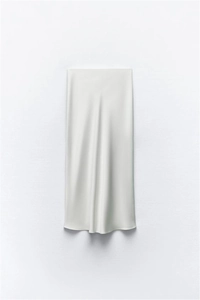 Detailed view of white midi skirt featuring premium satin texture and silk-like glossy finish