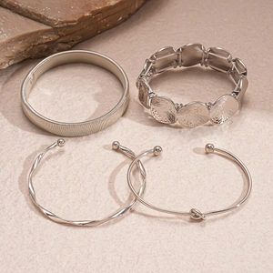 Detail of silver geometric bangles set featuring snake chain and knot designs on stone
