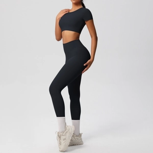 Vue latérale de l'ensemble de yoga noir deux pièces avec crop top et legging taille haute