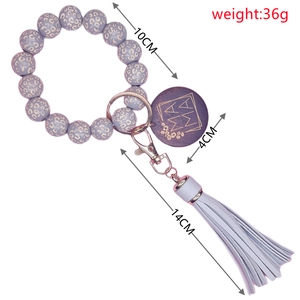 Détail du bracelet en perles de bois léopard lavande avec breloque MAMA et gland