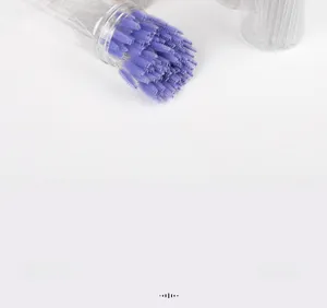 Close-up of disposable purple spiral eyelash brushes with glitter crystal handles in a container