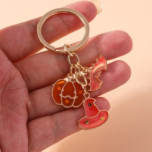 Detail of Halloween keychain with gold pumpkin, bat, and wizard hat pendants
