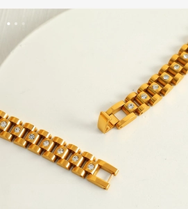Macro detail of 18k gold plated watch link bracelet with inlaid round cubic zirconia