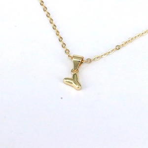 Detailed close-up of a minimalist golden letter Y pendant with a delicate thin chain