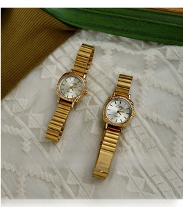 Close-up of vintage gold square ladies quartz watch with elastic band on lace background