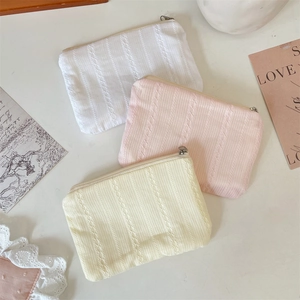 Detailed close-up of knitted makeup bags with vertical ribs and lace patterns