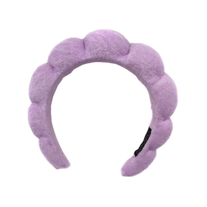 Padded purple headband with soft terry cloth texture for skincare and makeup rituals