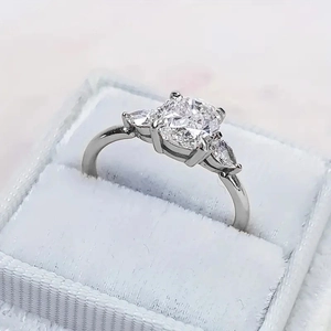 Klassieke drie-steens zirkonia ring met ronde kern en peervormige zijstenen in fluwelen doos