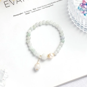 Detail view of light green beaded bracelet with elegant freshwater pearls and gold accents