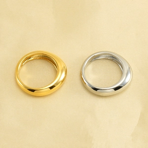 Polished minimalist 18k gold and silver stainless steel rings on silk background