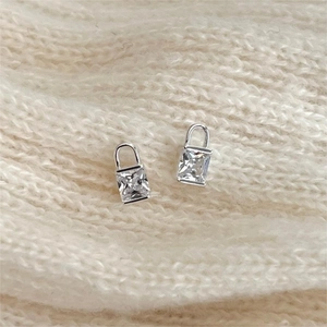 Minimalist S925 sterling silver lock earrings with square zircon on white knit background