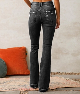 Detailed back view of black flared jeans with distressed ripped pockets and high-waisted fit