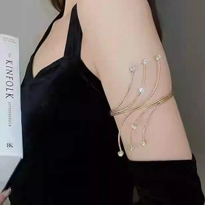 Elegant gold armlet with sparkling crystals featuring a unique curved multi-line design