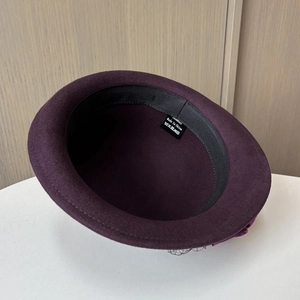 Detail shot of the 100% wool label and interior black sweatband of the purple felt hat