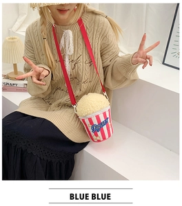 Cute popcorn bucket plush crossbody bag with red adjustable strap on a female model