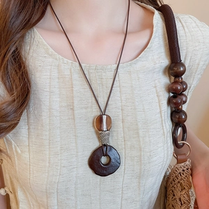 Detailed view of a vintage resin and wood square pendant on a long ethnic style necklace