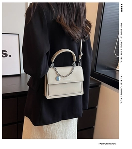 Chic cream-colored PU leather shoulder bag with gold chain strap and top handle detail
