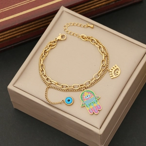 Double-layered gold necklace with enamel Hamsa hand and blue evil eye charms