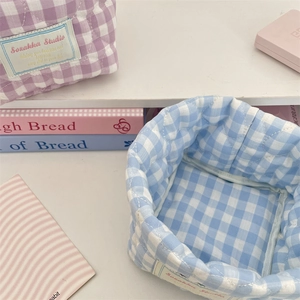 Detailed view of soft quilted checkerboard storage baskets with woven brand labels