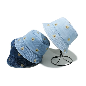 Three denim bucket hats with teddy bear embroidery in light, medium, and dark blue shades