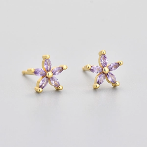 Macro detail of gold flower stud earrings with five purple marquise zircon petals