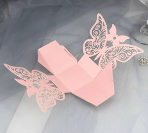 Detailed close-up of pink laser-cut butterfly wedding favor box with pearlescent texture