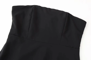 Close-up detail of the strapless neckline and premium black fabric texture on the dress