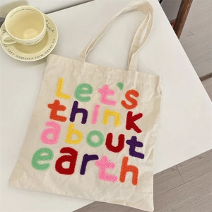 Detail of colorful chenille letter embroidery on off-white canvas tote bag