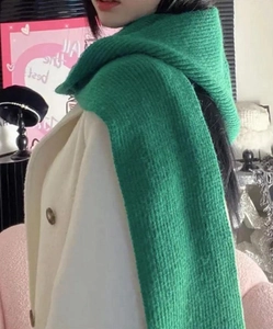 Detail view of the soft green knitted scarf texture and thermal weave on a model