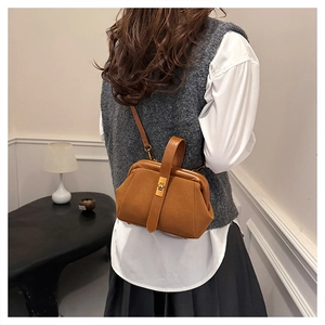 Detailed back view of model wearing a vintage brown matte shell bag with gold hardware