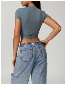 Close-up of slim fit short yoga top with denim jeans showing fabric texture and fit