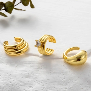 Three-piece gold ear cuff set with layered, textured, and teardrop minimalist designs