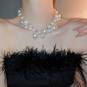 Close-up of oversized pearl necklace with layered white beads on model neck