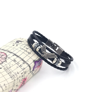 Dettaglio del bracciale multistrato in pelle con ciondolo aquila e perline metalliche