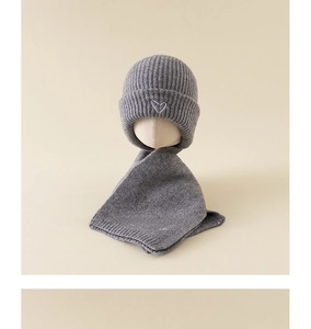 Close-up of grey ribbed knit beanie and scarf set featuring white heart embroidery