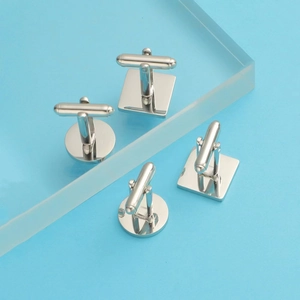 Macro view of mirror-polished silver square and round stainless steel cufflinks for men