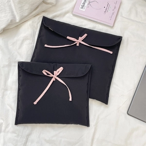 Dettaglio di borse per laptop trapuntate nere con fiocchi rosa in due dimensioni