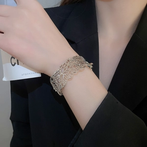 Detailed view of wide hollow butterfly open cuff bracelet in polished silver finish