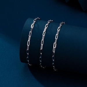 Macro detail of silver paperclip chain bracelet with polished rectangular links