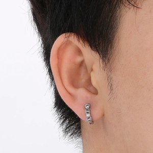 Close-up of silver titanium steel hoop earrings with sparkling cubic zirconia on ear