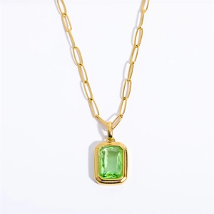 Detail of emerald cut green zircon pendant with 18k gold plated paperclip chain