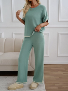 Detail of grey-green knit set featuring short-sleeve top and beige trim wide-leg pants