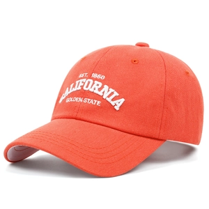 Detailed close-up of premium CALIFORNIA 3D embroidery on a bright orange cotton cap