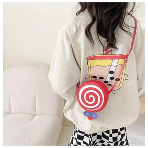 Kids' lollipop shaped crossbody bag in red with a blue bow worn on a shoulder