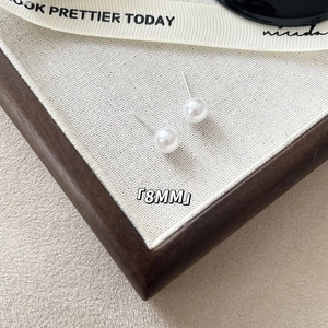 Close-up detail of 8mm classic round white pearl stud earring with S925 silver needle