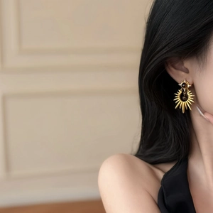 Retro golden sunburst stud earrings with tiger eye stone on model for elegant styling