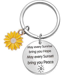 Close-up of sunflower keychain with engraved inspirational quote on stainless steel disc