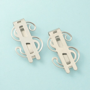 Detail of dollar sign stainless steel money clips with a brushed metal finish texture