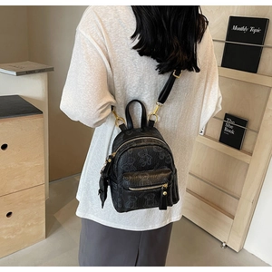 Vue arrière d'un mannequin portant un mini sac à dos noir avec motifs d'ours