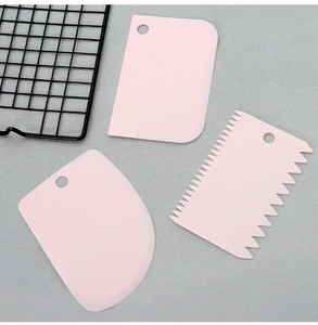 Three-piece pink plastic dough scraper set including straight, curved, and jagged edges